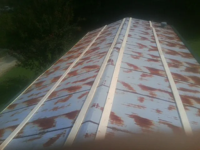 Rusted metal roof panels with new wood purlins before replacement — Storm Damage Roof Repair in Oketo by Roofing Brothers
