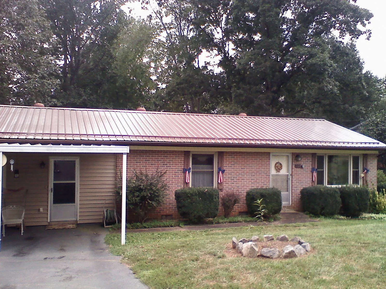 Bronze metal roof and carport on a brick ranch home — Roof Repair work by our crew in Oketo